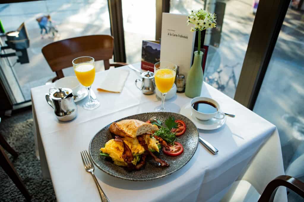 Gedeckter Frühstückstich mit Café, Oregansaft und 